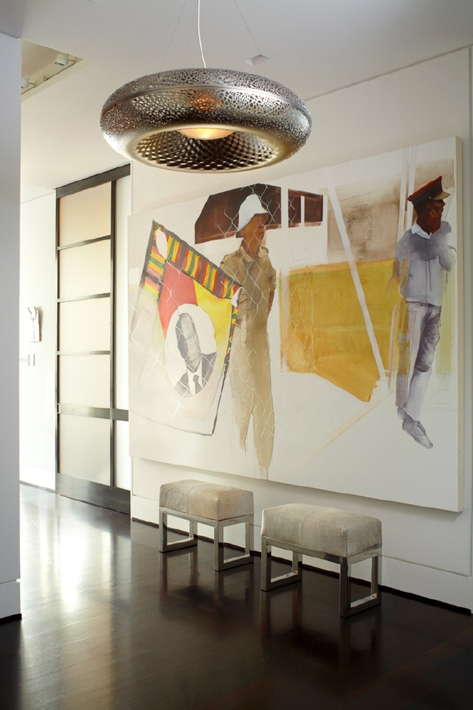 photo of entry way with contemporary artwork and circular overhead light fixture