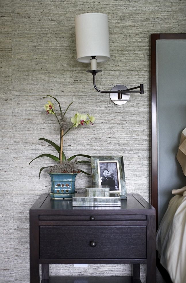 photo of wooden bedside table with orchids and framed photo