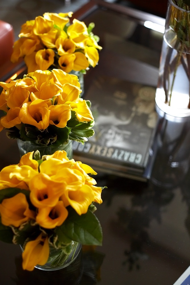 Photo of yellow flowers in vases on coffee table