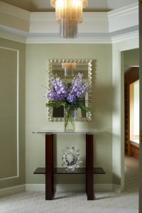photo of entry way with metal mirror and purple flowers