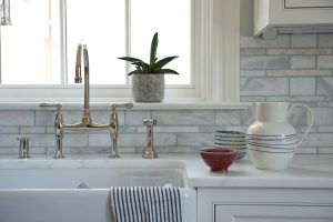 photo of white with gray kitchen counter, cabinets, sink and backsplash