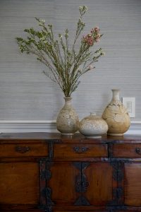 photo of antique sideboard with natural vases