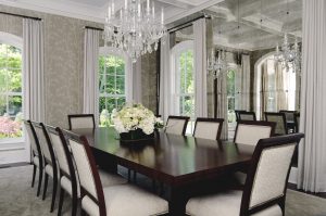 photo of formal dining room with geometric upholstered cream chairs and glass bead chandelier