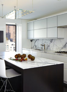 Contemporary sleek kitchen design detail showing lit rectangular glass ceiling light
