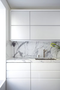 Contemporary sleek kitchen design detail showing marble counter and back