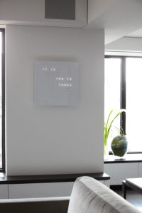 Contemporary living room design detail showing textual custom clock
